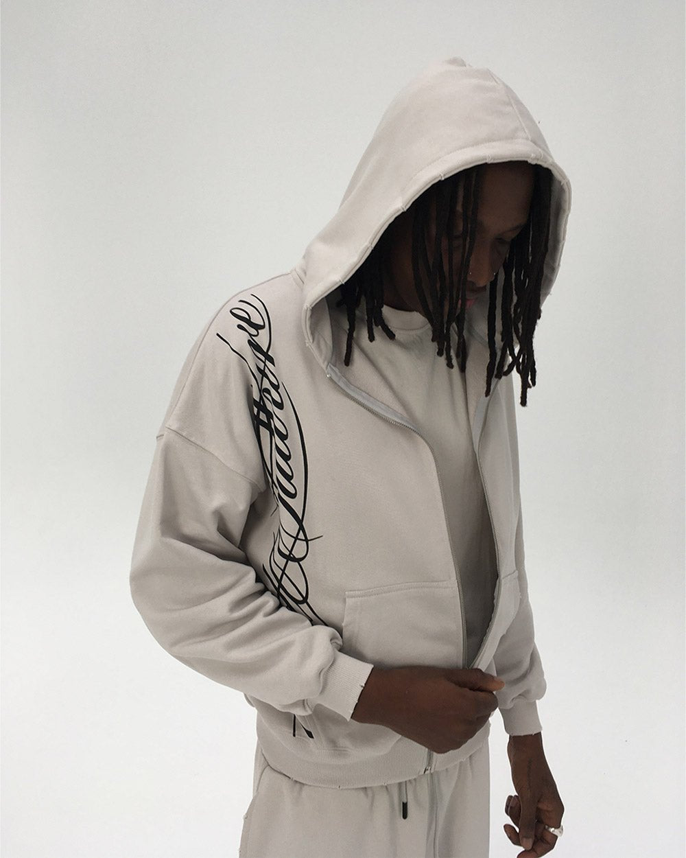 SCRIPT ZIP HOODIE LIGHT GREY - light grey script print zip hoodie, on model close-up - Cold Culture