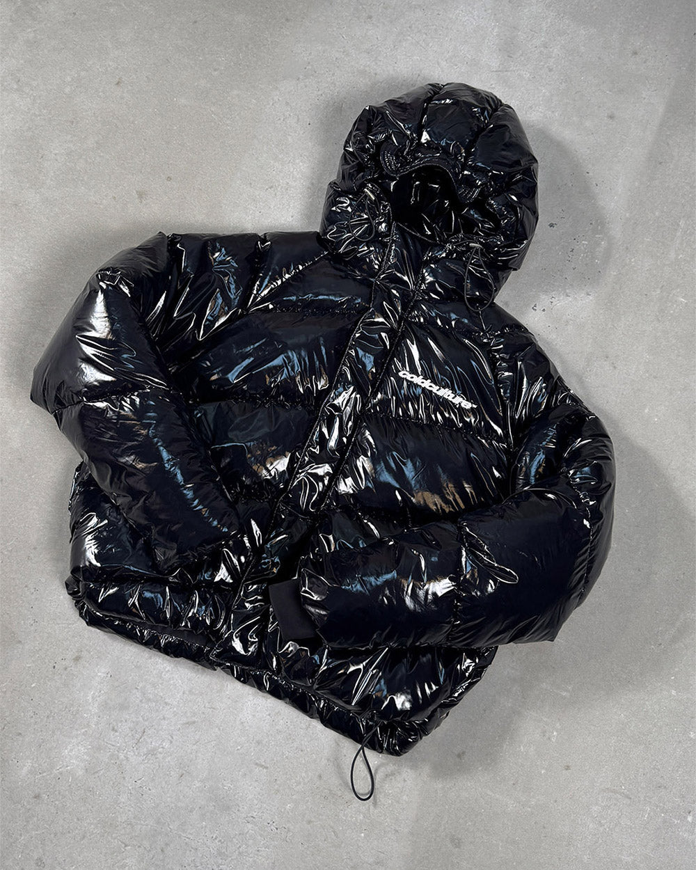SPIRAL PUFFER GLOSSY BLACK - glossy black puffer jacket, flat lay - Cold Culture