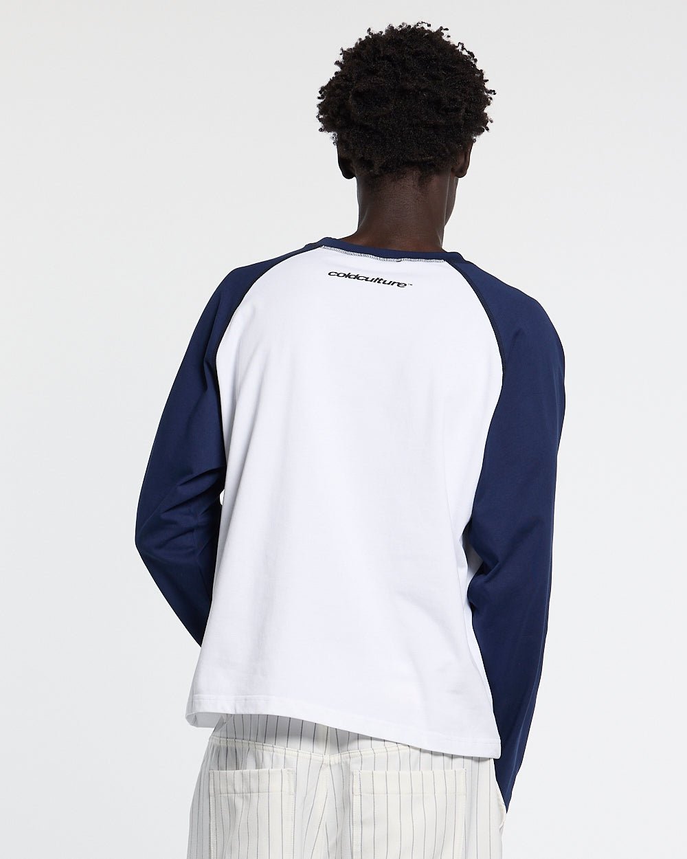 STARSHIELD LONGSLEEVE BLUE - white and navy raglan longsleeve tee, back view on male model - Cold Culture #man