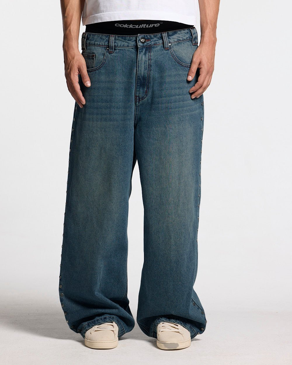 STUDS PANTS LIGHT BLUE DENIM - washed blue studded denim pants, front view on male model - Cold Culture