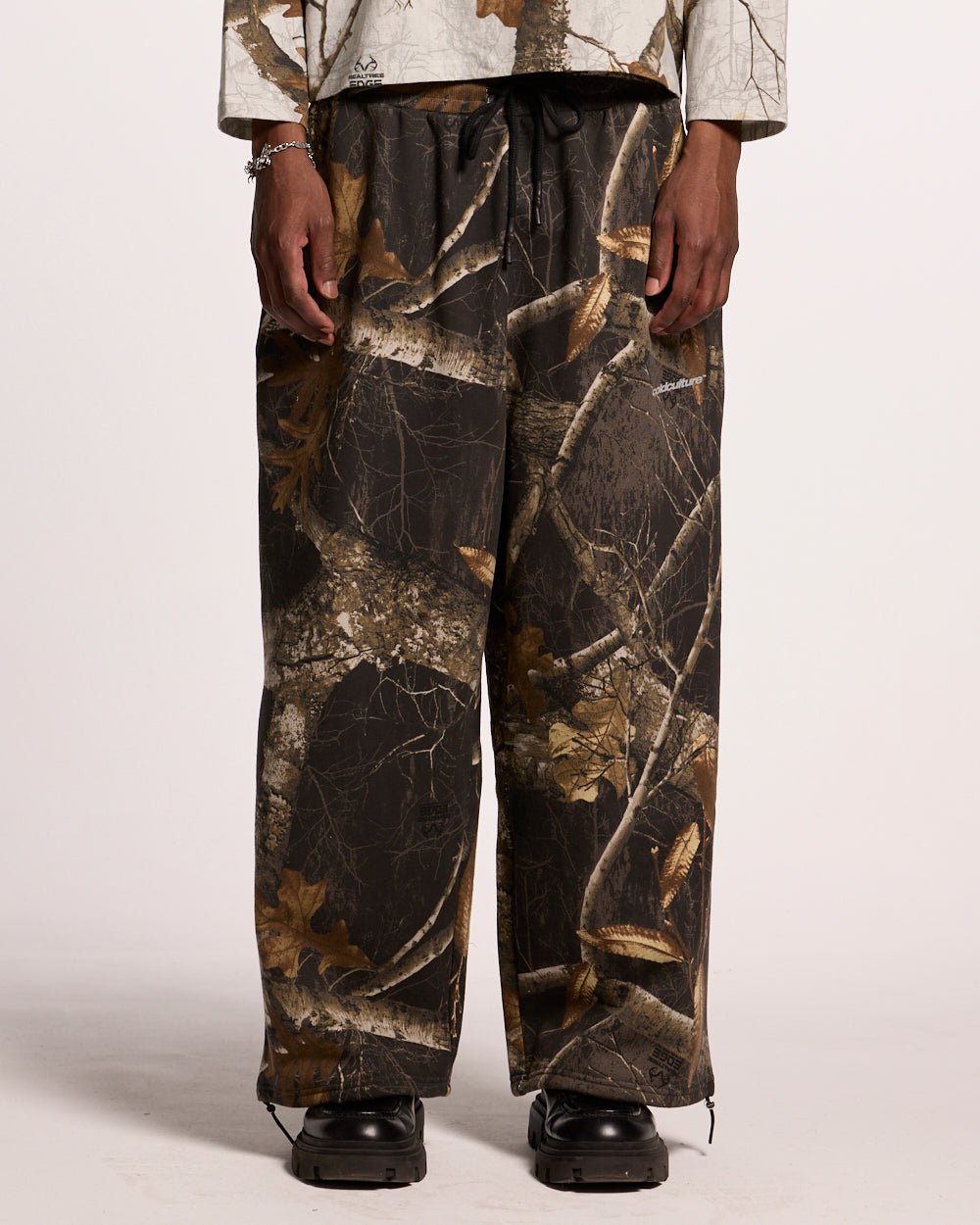 SWEATPANTS REALTREE BLACK - black camo sweatpants, front view on male model - Cold Culture