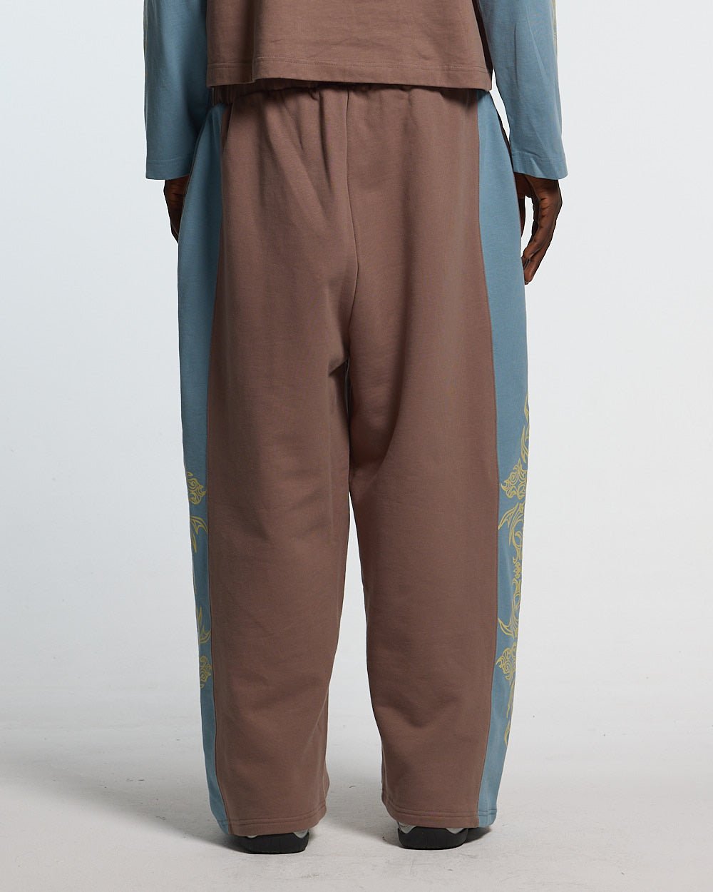 TRIBAL SWEATPANTS BROWN & BLUE - brown and blue tribal sweatpants, back view on male model - Cold Culture