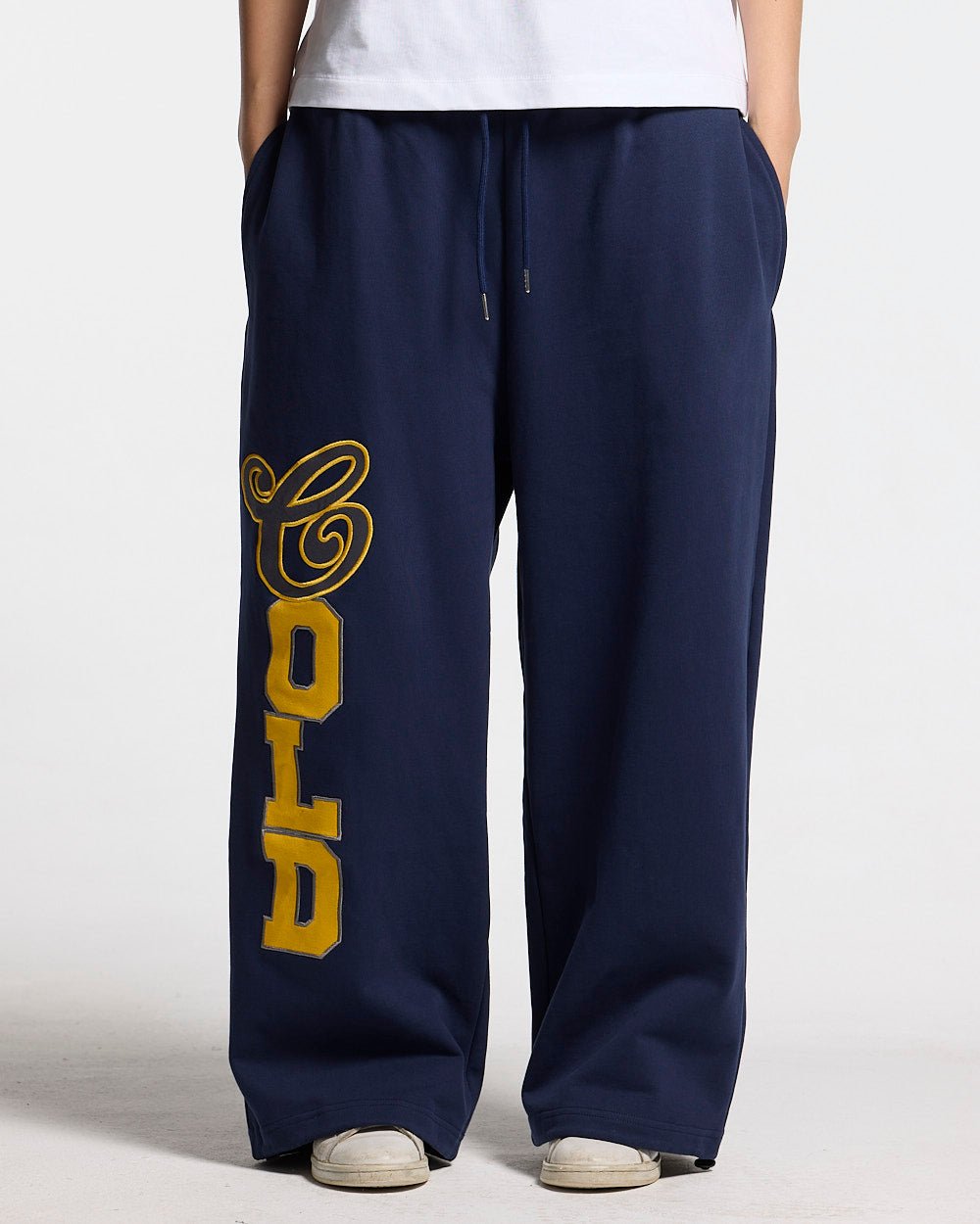 VARSITY PANTS DARK BLUE - navy blue baggy sweatpants, front view on female model - Cold Culture #woman