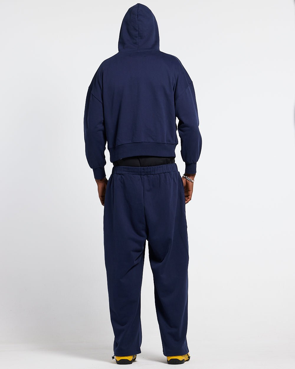 VARSITY PANTS DARK BLUE - navy blue baggy sweatpants, back view on male model - Cold Culture