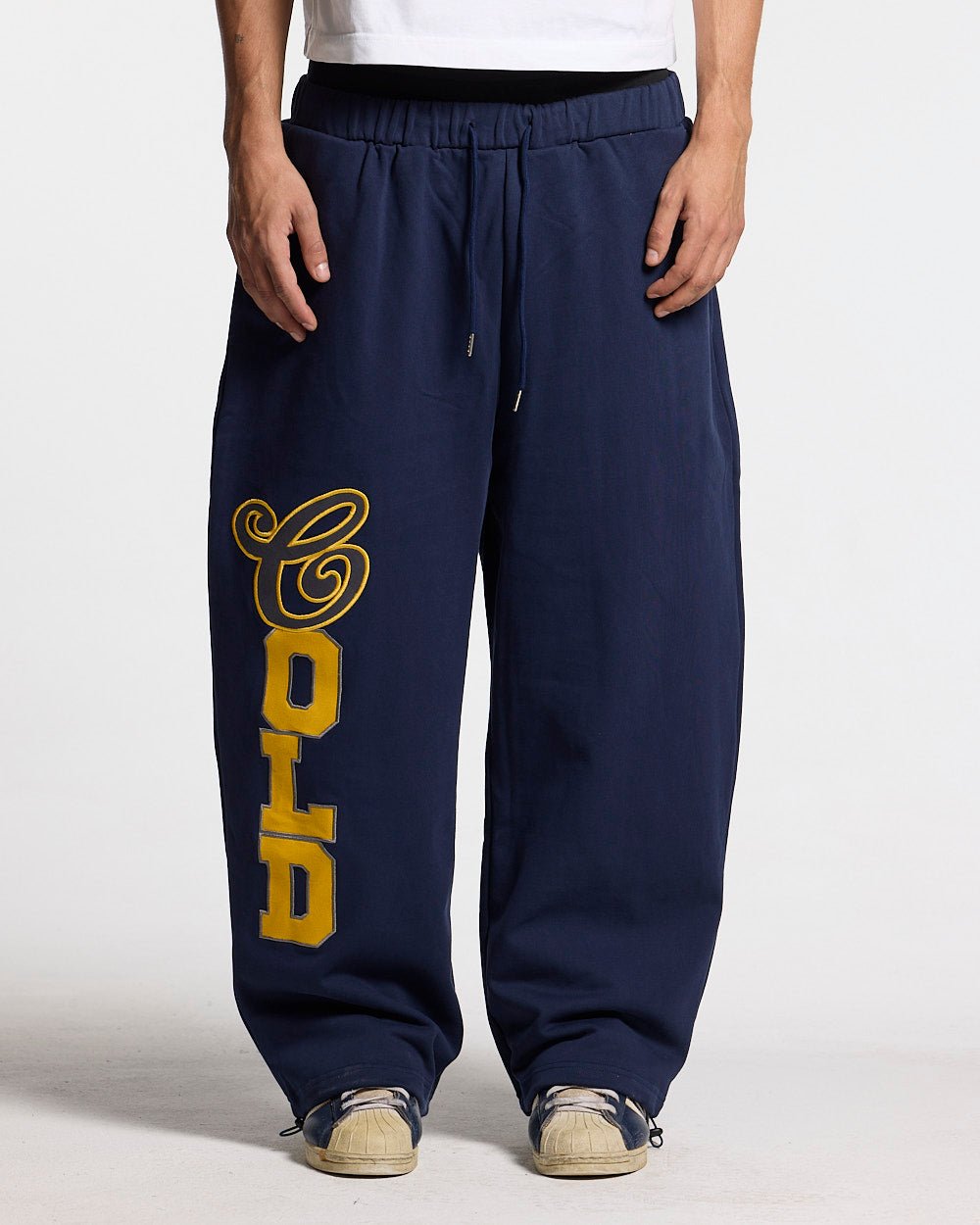 VARSITY PANTS DARK BLUE - navy blue baggy sweatpants, front view on male model - Cold Culture