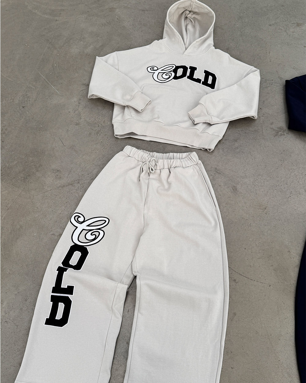 VARSITY PANTS IVORY GREY - ivory grey baggy sweatpants, flat lay with matching pieces - Cold Culture