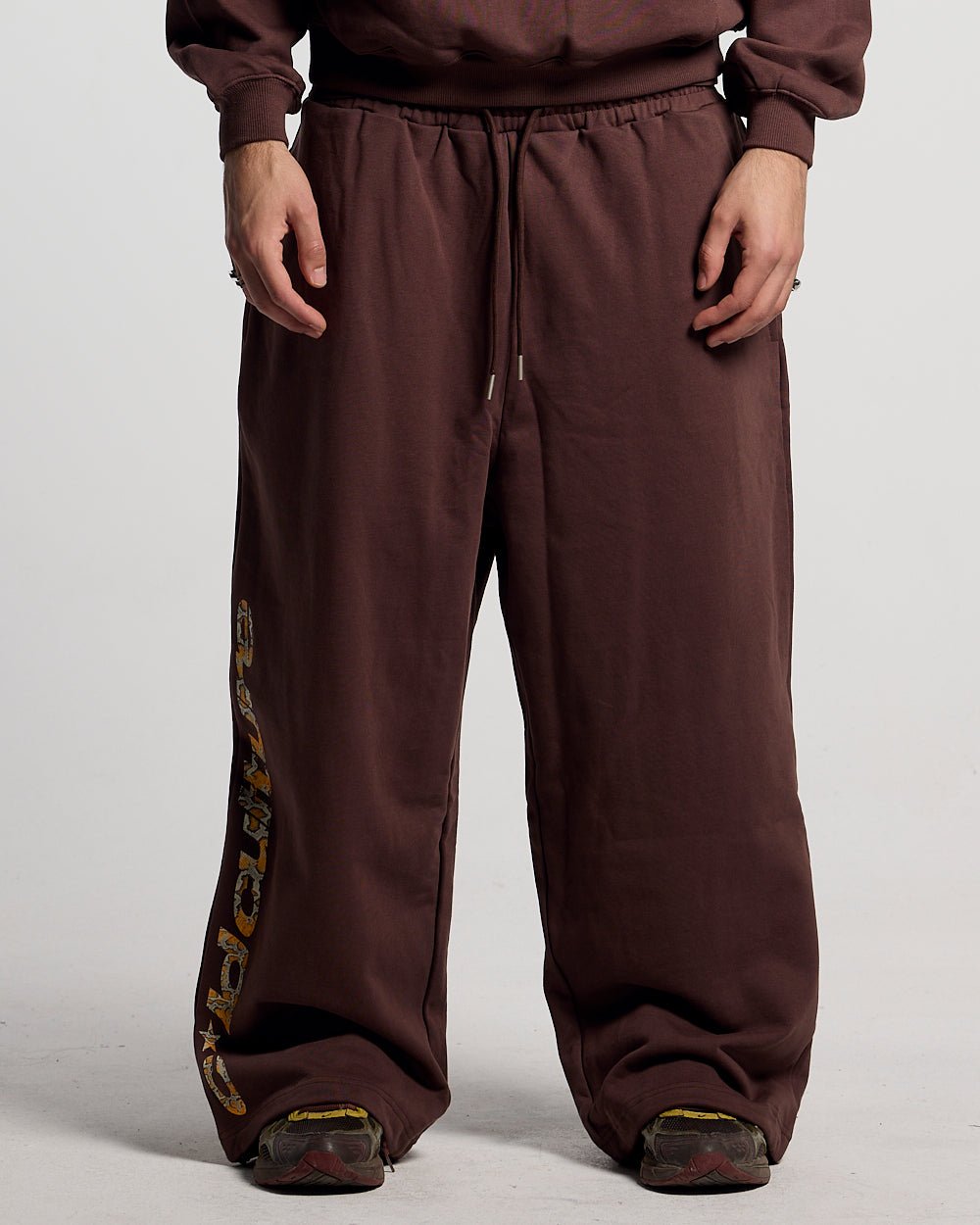 WILD SNAKE SWEATPANTS BROWN - brown baggy sweatpants, front view on male model - Cold Culture
