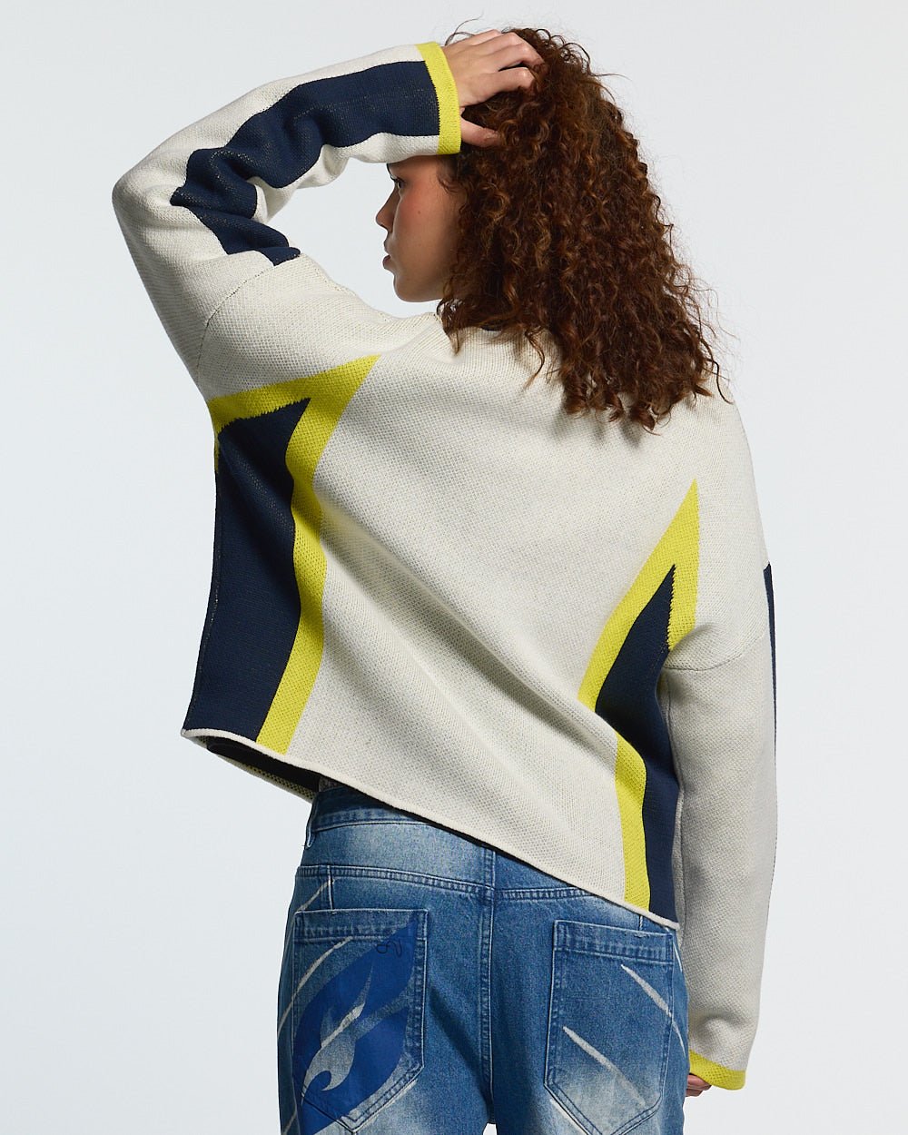 WINNER KNIT BEIGE, DARK BLUE & YELLOW - beige and navy knit sweater, back view on female model - Cold Culture #woman